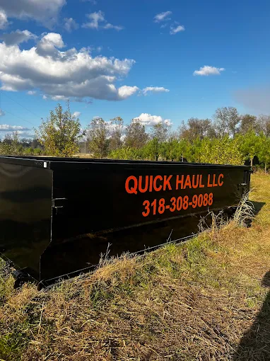 Quick Haul roll-off dumpster with the company name and phone number